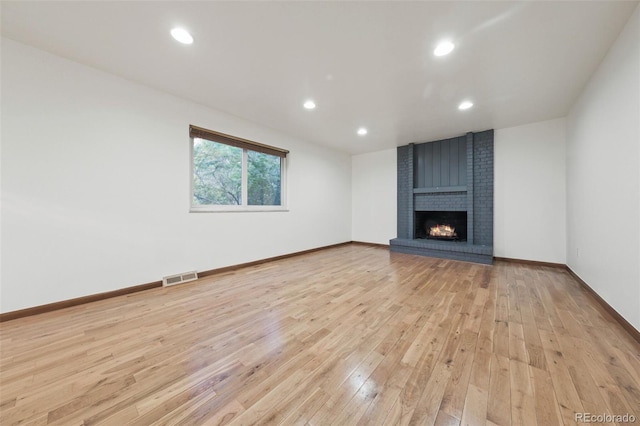 unfurnished living room with light wood-type flooring and a fireplace