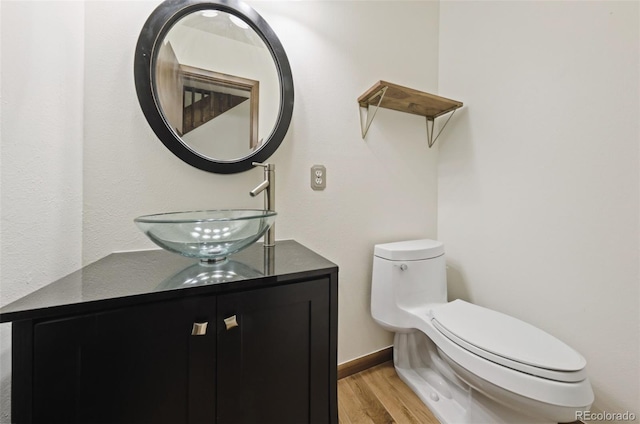 bathroom featuring hardwood / wood-style floors, vanity, and toilet