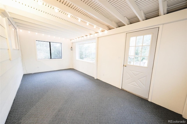 carpeted entrance foyer featuring beamed ceiling and a healthy amount of sunlight