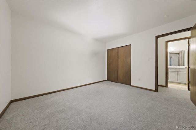 unfurnished bedroom featuring light carpet and a closet