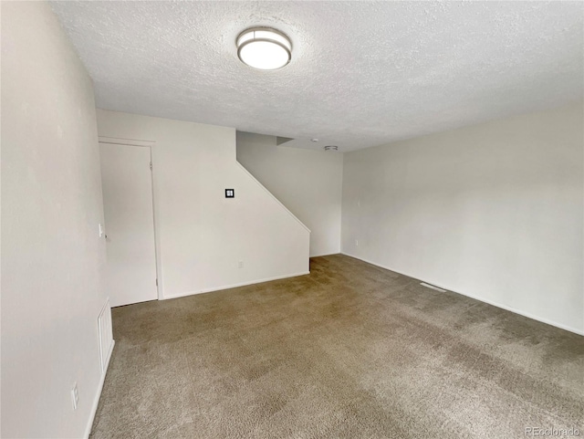 spare room with carpet and a textured ceiling