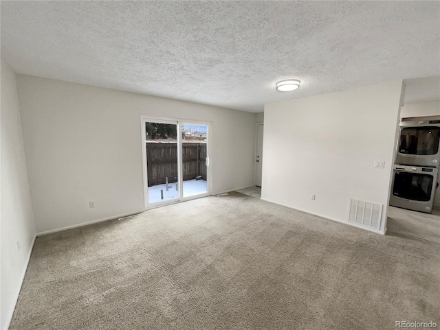 empty room with light carpet and a textured ceiling