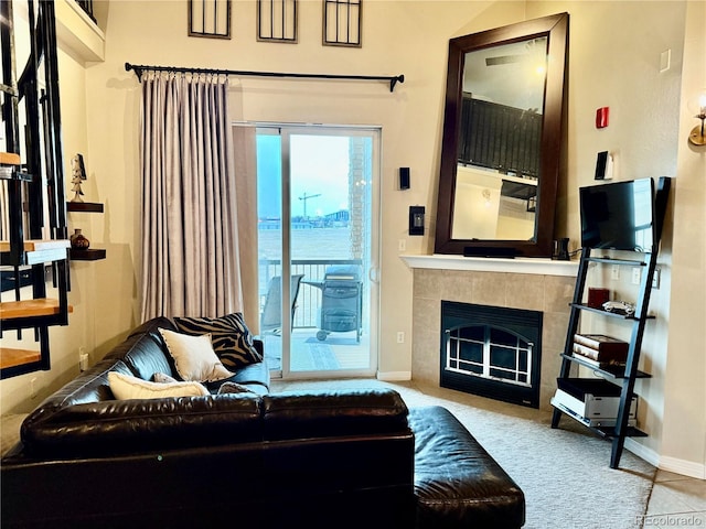 living area with baseboards and a tiled fireplace