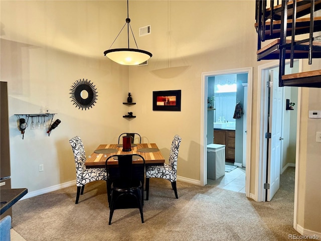 dining area with light carpet, visible vents, and baseboards