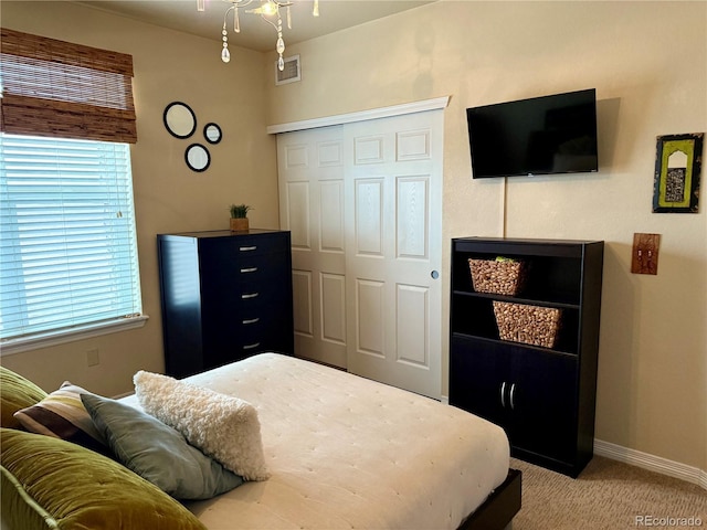 bedroom featuring baseboards, visible vents, a closet, and light colored carpet