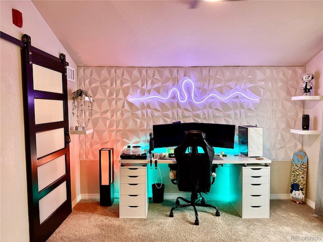 unfurnished office featuring baseboards, a barn door, and light colored carpet