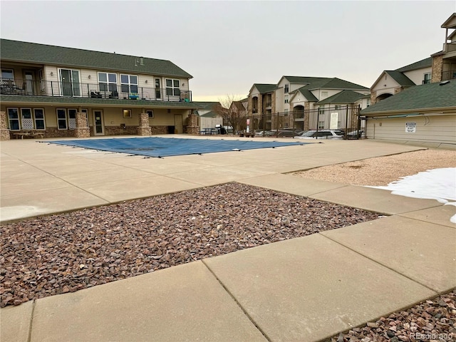 pool with a patio and fence