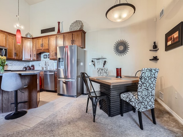 kitchen featuring tasteful backsplash, light tile patterned floors, visible vents, and stainless steel appliances