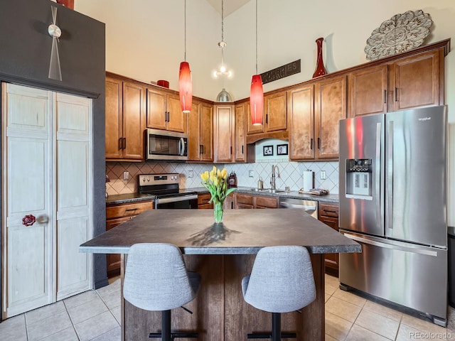 kitchen featuring light tile patterned floors, stainless steel appliances, and dark countertops