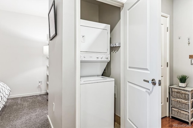 2958 Syracuse St Unit 214, Denver, CO 80238 - clothes washing area featuring baseboards, laundry area, stacked washer and dryer, and dark carpet