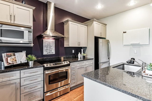 2958 Syracuse St Unit 214, Denver, CO 80238 - kitchen featuring light wood-style floors, wall chimney range hood, recessed lighting, a sink, and stainless steel appliances