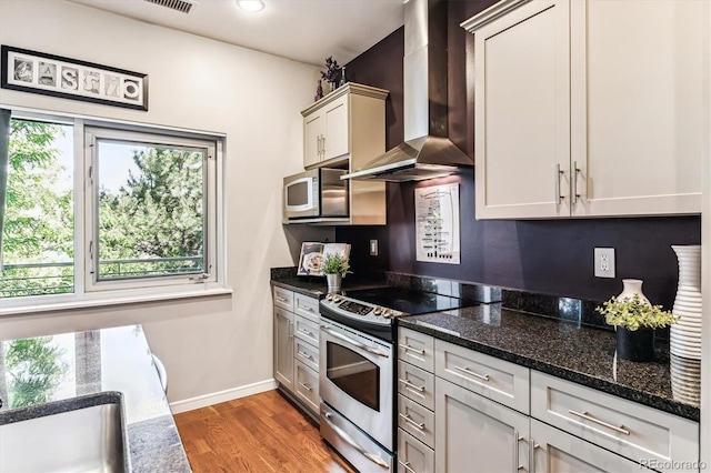 2958 Syracuse St Unit 214, Denver, CO 80238 - kitchen featuring wall chimney range hood, stainless steel electric range, recessed lighting, baseboards, and wood finished floors