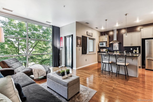 2958 Syracuse St Unit 214, Denver, CO 80238 - living area with baseboards, visible vents, a wall of windows, and light wood-style flooring