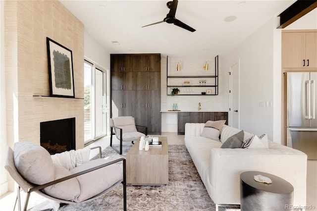 living room with ceiling fan and a fireplace