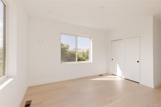 unfurnished bedroom featuring a closet and light hardwood / wood-style floors