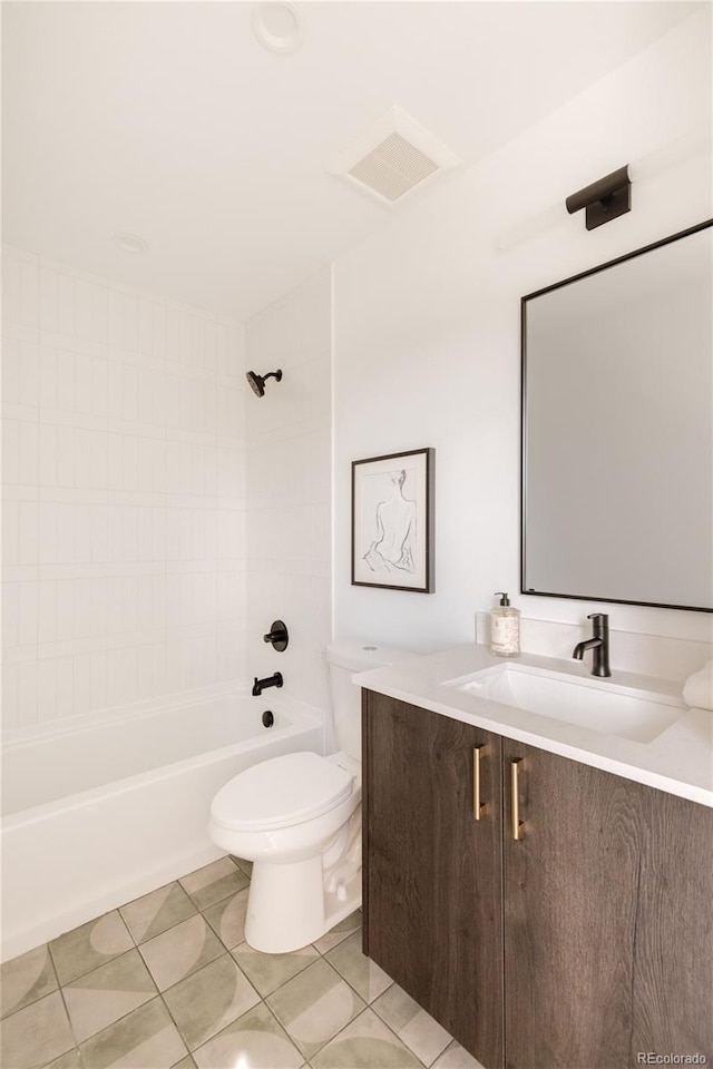 full bathroom featuring tiled shower / bath, vanity, toilet, and tile patterned flooring