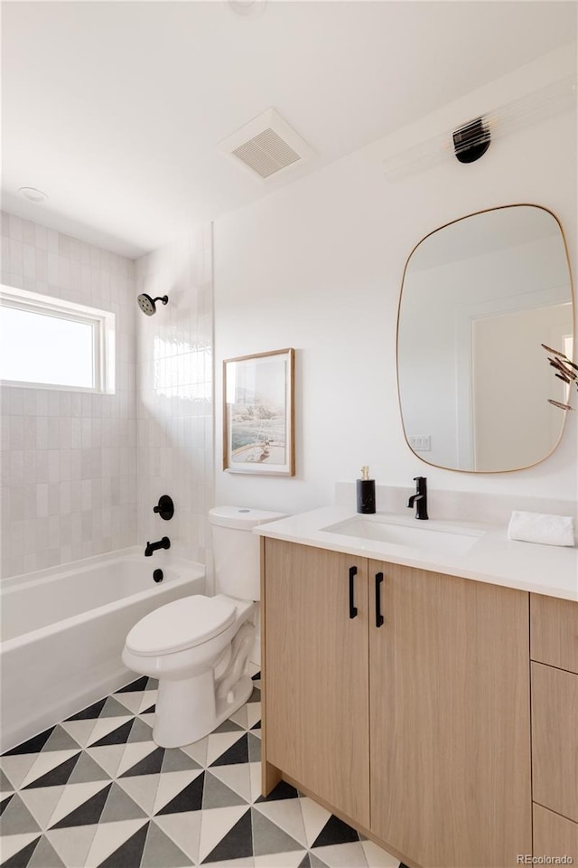 full bathroom featuring vanity, toilet, and tiled shower / bath