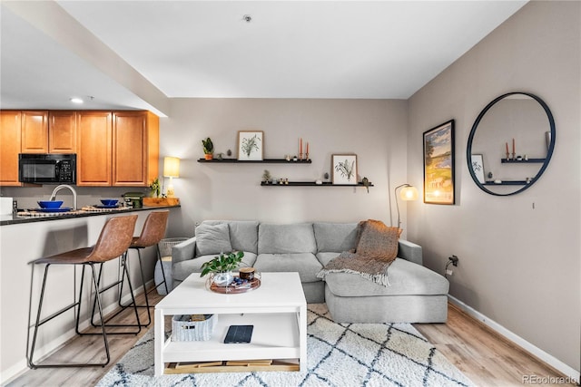 living room featuring light wood finished floors and baseboards