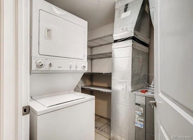 washroom with stacked washer and dryer and laundry area