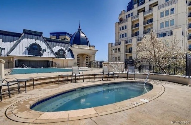 view of swimming pool featuring a patio and fence