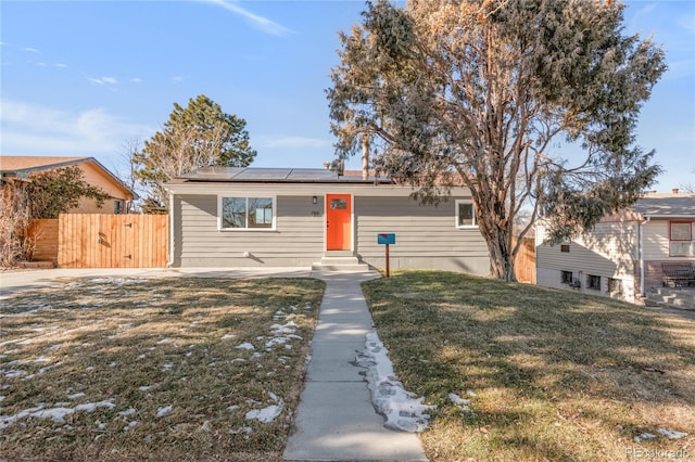 view of front of house featuring a front lawn and solar panels