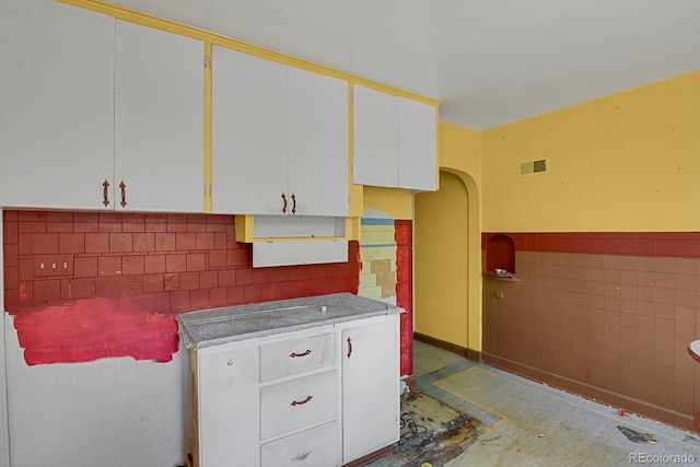 577 96th St, Louisville, CO 80027 - kitchen with tile walls, white cabinets, arched walkways, and wainscoting