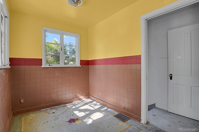 unfurnished room with tile walls