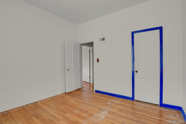 empty room with light hardwood / wood-style flooring