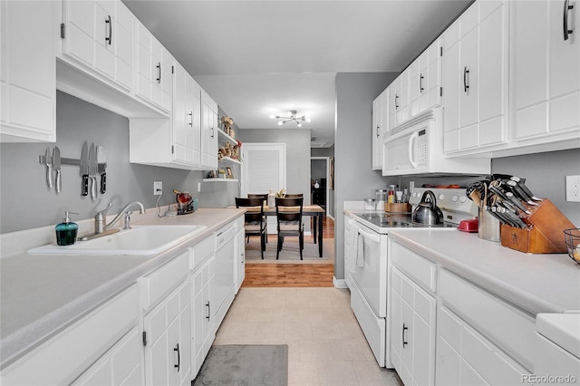 kitchen featuring sink, white appliances, and white cabinets