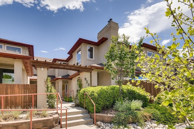 920 S Locust St Unit E, Denver, CO 80224 - view of front of home featuring stucco siding and a chimney