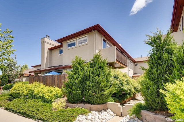 920 S Locust St Unit E, Denver, CO 80224 - view of property exterior featuring stucco siding and a chimney