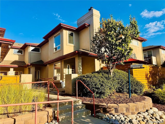 920 S Locust St Unit E, Denver, CO 80224 - view of front of home featuring stucco siding and a chimney