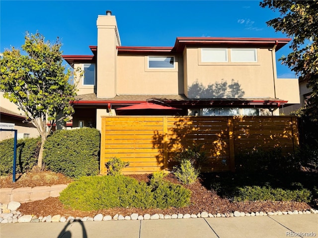 920 S Locust St Unit E, Denver, CO 80224 - view of front of home with stucco siding and a chimney