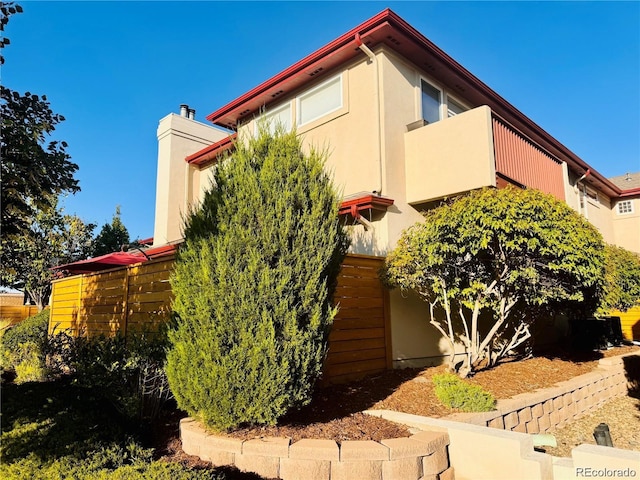 920 S Locust St Unit E, Denver, CO 80224 - view of front of house with stucco siding, stairs, a balcony, and a chimney