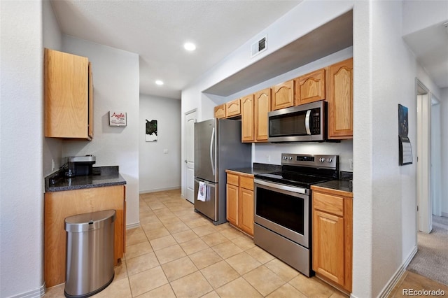 920 S Locust St Unit E, Denver, CO 80224 - kitchen with appliances with stainless steel finishes, dark countertops, light tile patterned floors, and recessed lighting