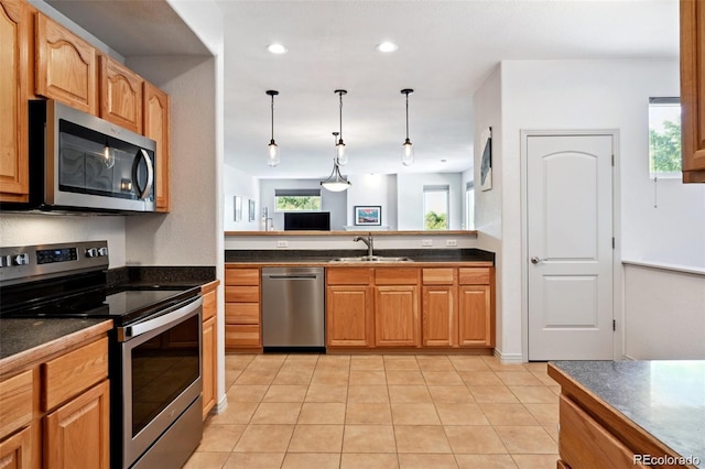 920 S Locust St Unit E, Denver, CO 80224 - kitchen with stainless steel appliances, dark countertops, decorative light fixtures, light tile patterned floors, and recessed lighting