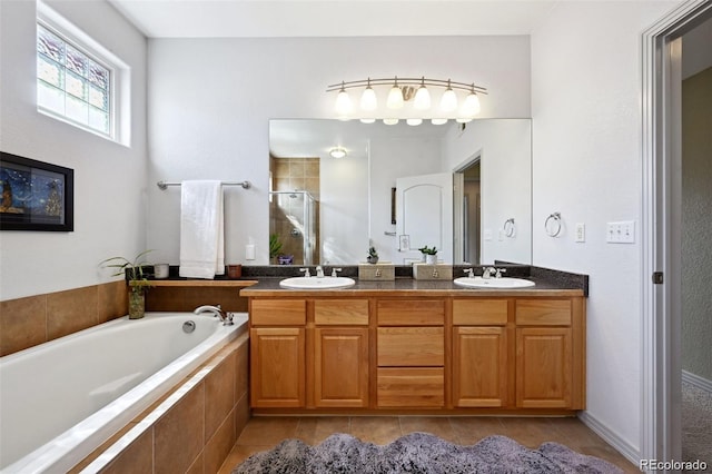 920 S Locust St Unit E, Denver, CO 80224 - full bathroom featuring tile patterned floors, double vanity, a shower stall, and a garden tub