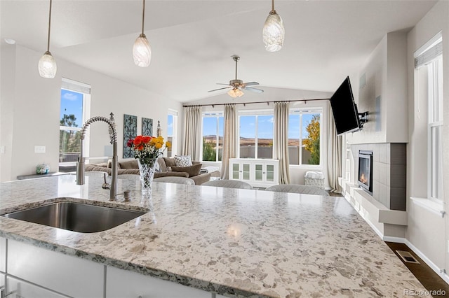 kitchen featuring sink, hanging light fixtures, and vaulted ceiling