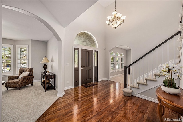 entryway with a chandelier, hardwood / wood-style floors, and high vaulted ceiling