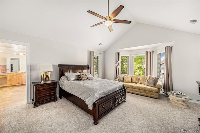 bedroom featuring connected bathroom, light colored carpet, high vaulted ceiling, and ceiling fan