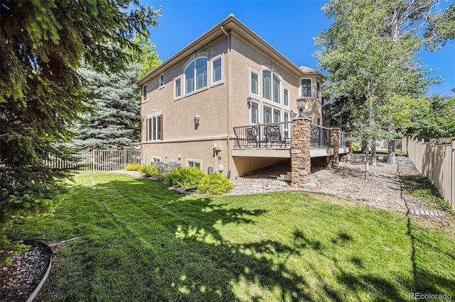 back of house with a lawn and a wooden deck