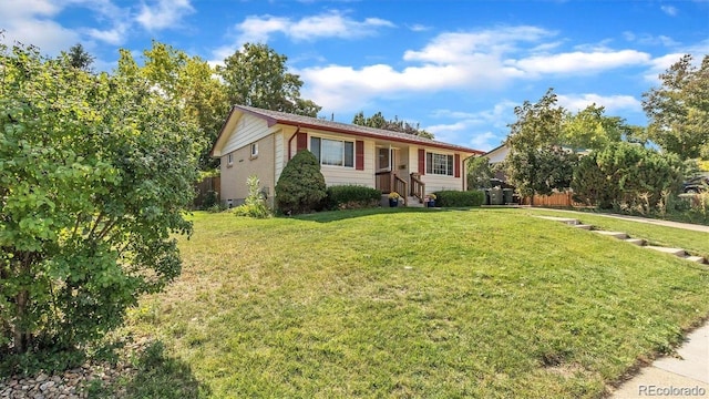 ranch-style home featuring a front lawn and fence