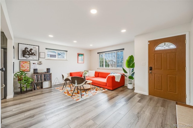 living room featuring recessed lighting, baseboards, and light wood finished floors