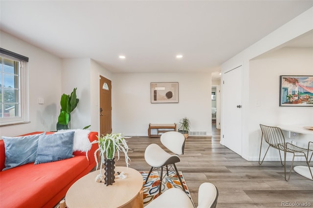 living room featuring recessed lighting, visible vents, baseboards, and wood finished floors