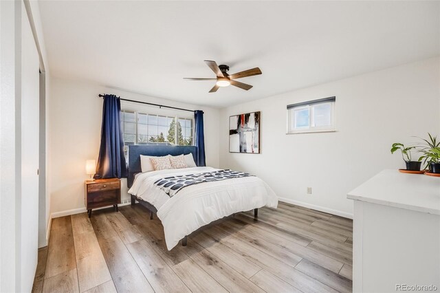 bedroom featuring baseboards, light wood-style floors, and ceiling fan