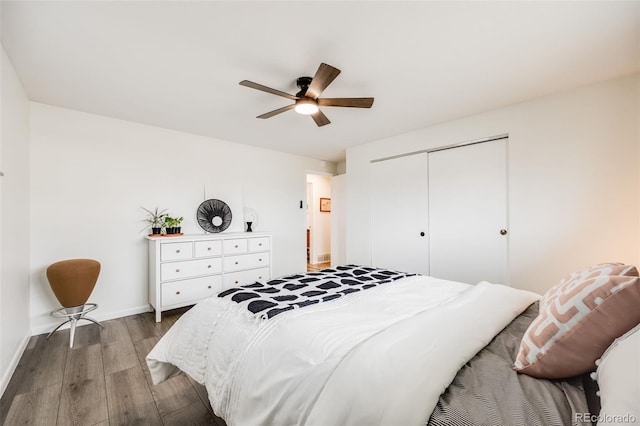 bedroom featuring a closet, a ceiling fan, baseboards, and wood finished floors