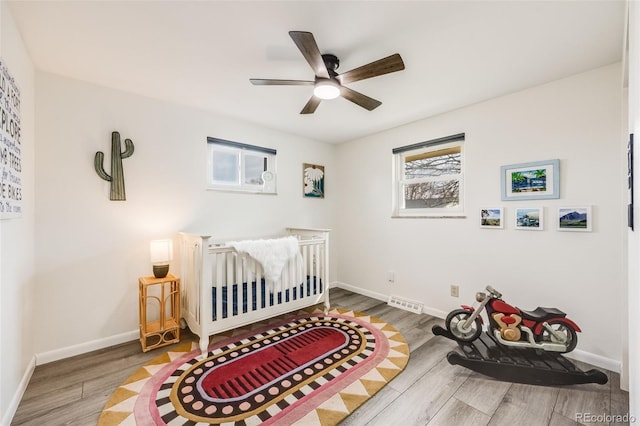 bedroom with a ceiling fan, baseboards, and wood finished floors