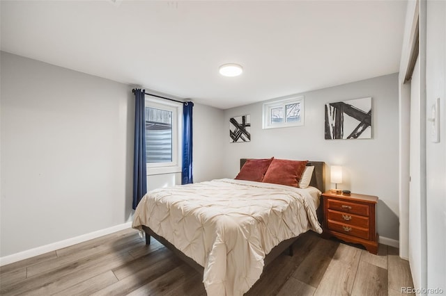 bedroom featuring wood finished floors and baseboards