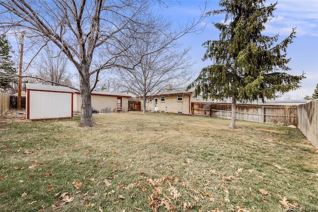 view of yard featuring an outdoor structure, a fenced backyard, and a shed