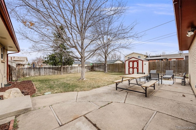 view of patio featuring an outbuilding, a storage unit, and a fenced backyard